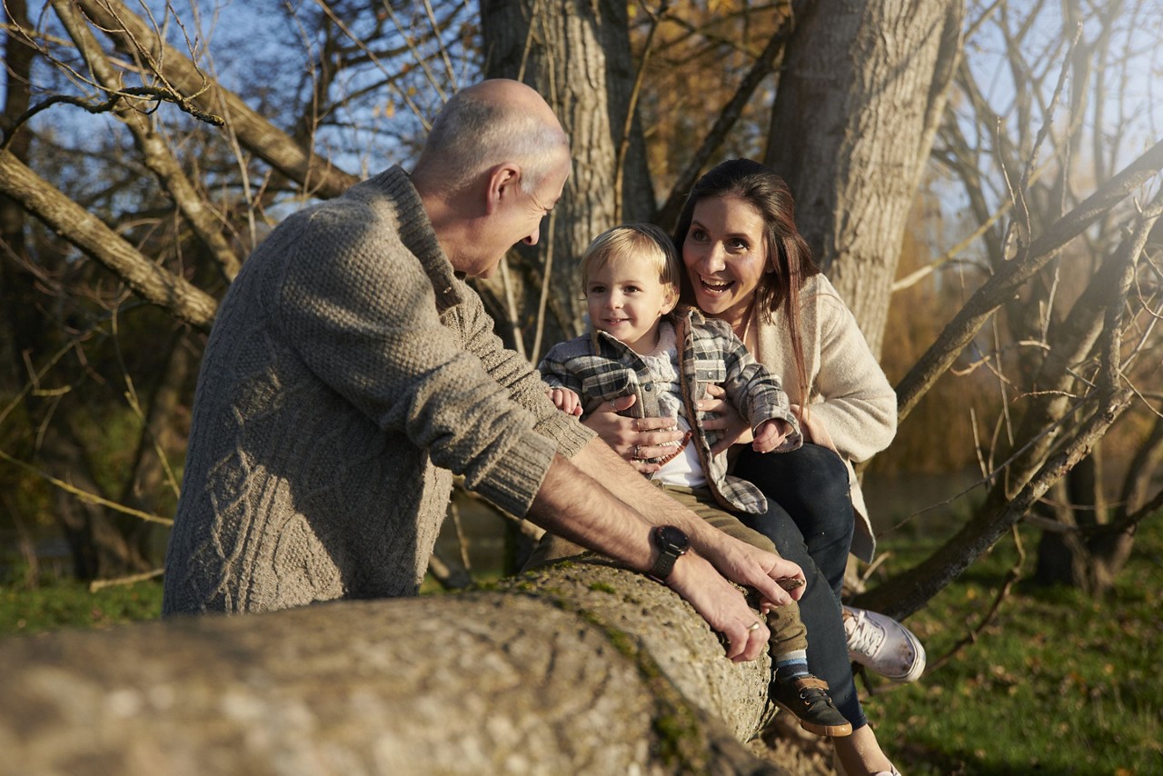 Grandfather mother and son playing on tree trunk mirrored